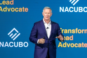 Bill McRaven, a white man with gray hair wearing a suit, speaks at NACUBO